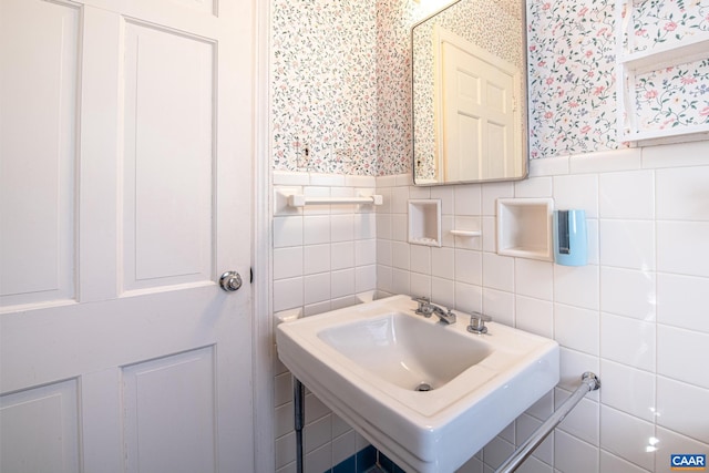 bathroom featuring sink and tile walls