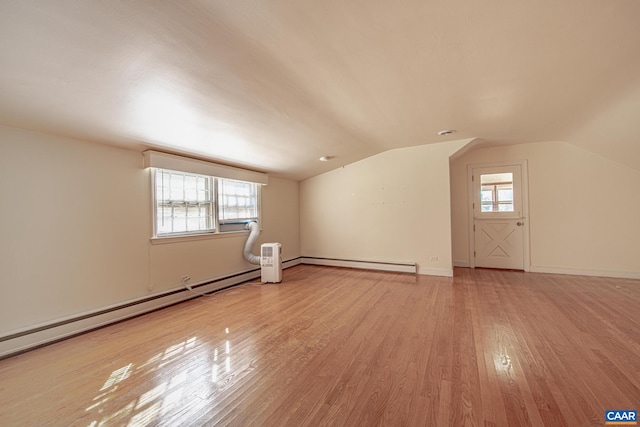 additional living space with light hardwood / wood-style floors, plenty of natural light, and lofted ceiling