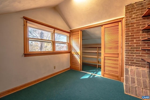 unfurnished bedroom with a closet, lofted ceiling, and dark carpet