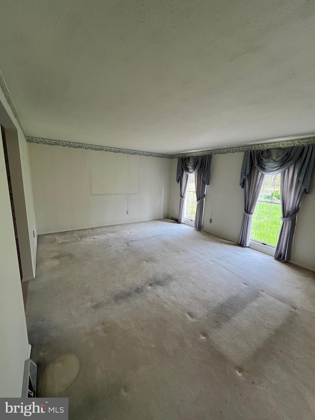 unfurnished room featuring a wealth of natural light and a textured ceiling