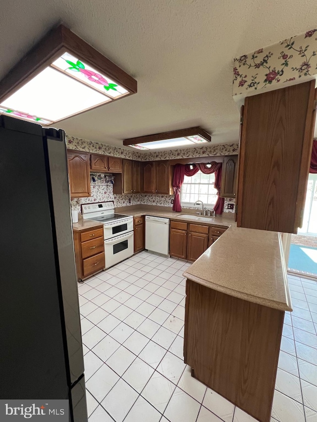 kitchen featuring white appliances, sink, kitchen peninsula, and light tile floors