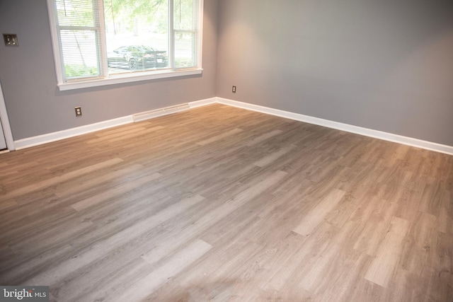 spare room with a baseboard heating unit and hardwood / wood-style floors