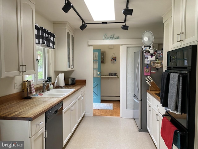 kitchen featuring rail lighting, a baseboard heating unit, wood counters, black appliances, and sink