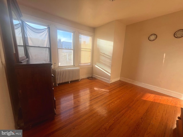 empty room featuring dark hardwood / wood-style floors and radiator