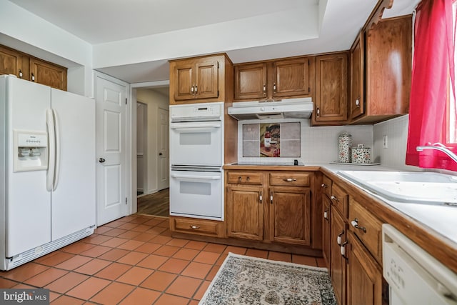 kitchen featuring backsplash, light hardwood / wood-style flooring, white appliances, and sink