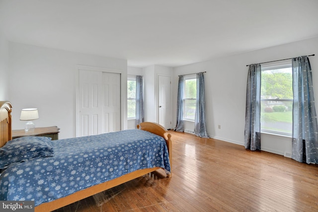 bedroom with hardwood / wood-style flooring and multiple windows