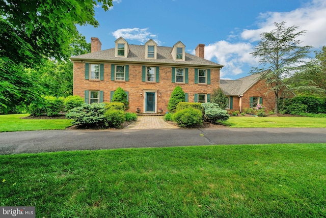 colonial-style house with a front lawn