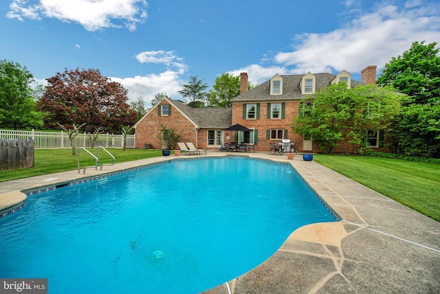 view of swimming pool with a patio and a yard