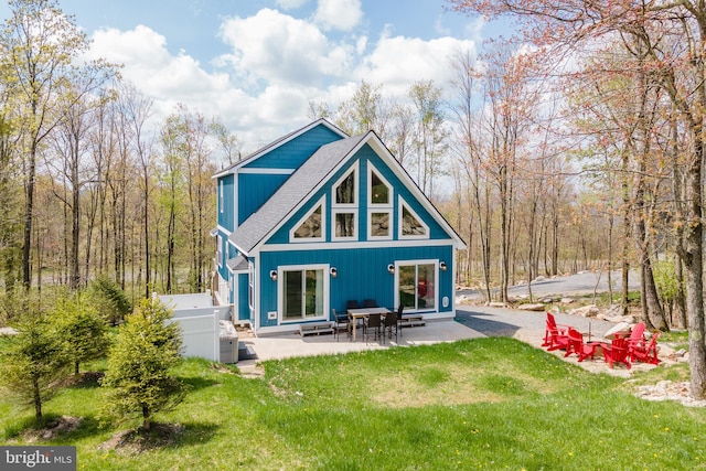 back of property with a patio area and a lawn