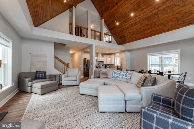 living room with hardwood / wood-style flooring, plenty of natural light, and a towering ceiling