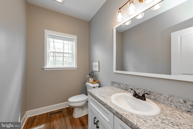 bathroom with hardwood / wood-style flooring, toilet, and vanity