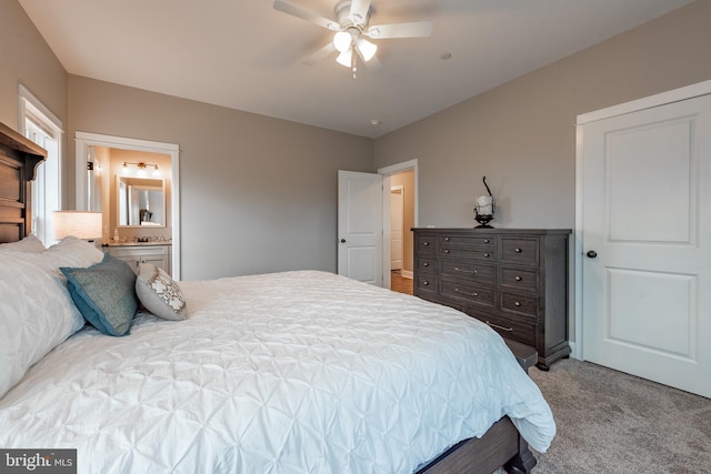 carpeted bedroom featuring ensuite bath and ceiling fan