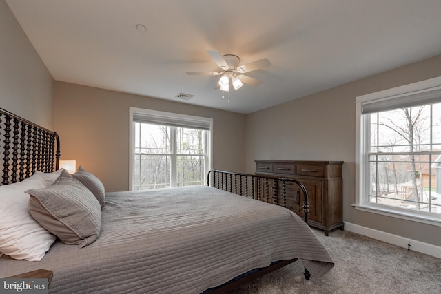 carpeted bedroom featuring ceiling fan and multiple windows