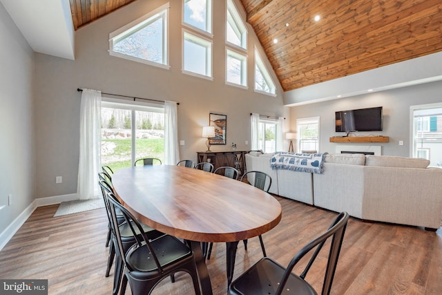 dining room with wooden ceiling, a wealth of natural light, high vaulted ceiling, and wood-type flooring