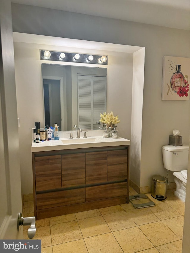 bathroom with tile flooring, oversized vanity, and toilet