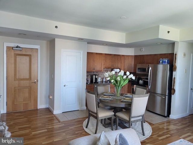 kitchen featuring tile flooring, backsplash, and stainless steel appliances