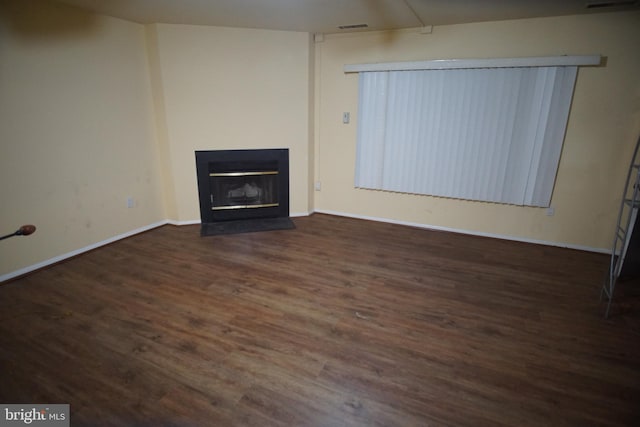 unfurnished living room with dark wood-type flooring