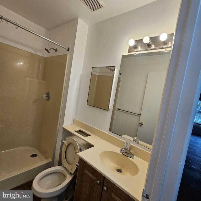 bathroom with a shower, vanity, and toilet