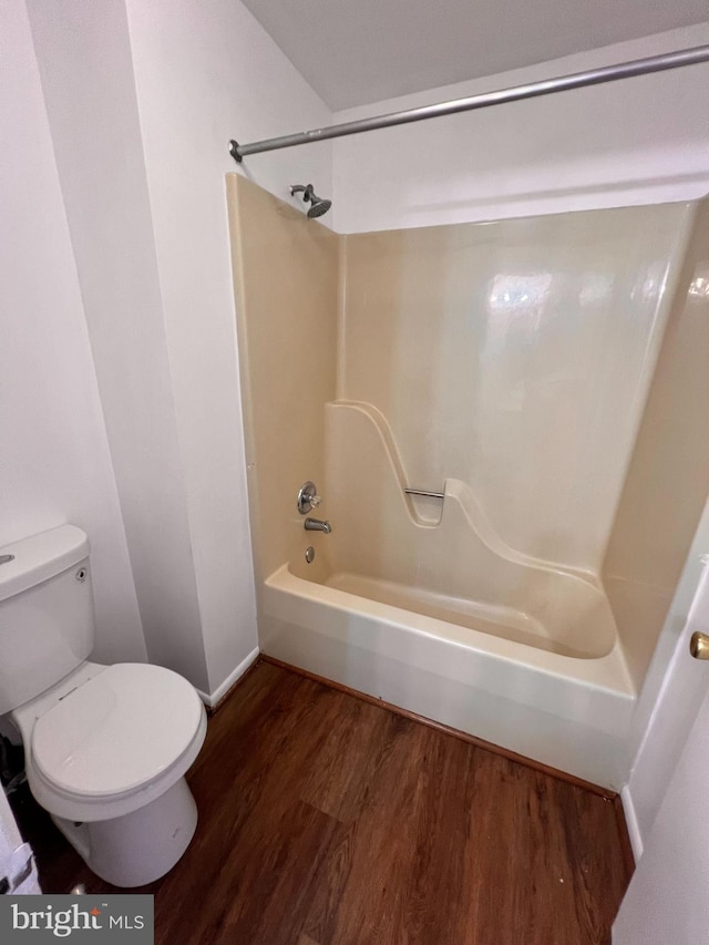 bathroom with shower / bath combination, wood-type flooring, and toilet