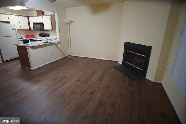 kitchen featuring a breakfast bar, white refrigerator, kitchen peninsula, electric stove, and white cabinets