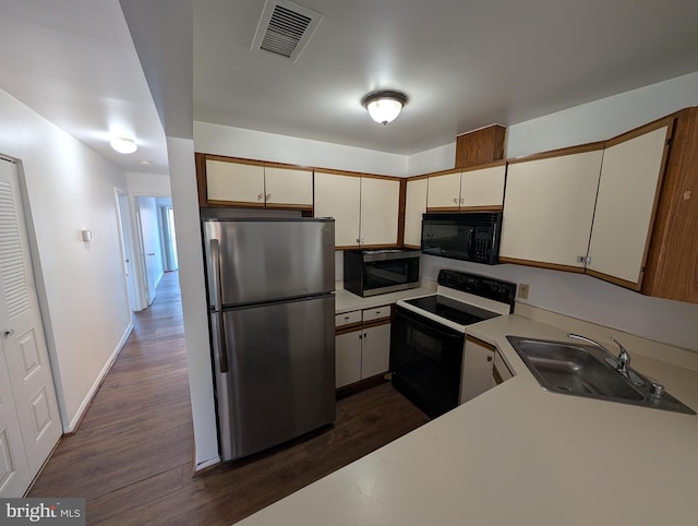 kitchen featuring appliances with stainless steel finishes, dark hardwood / wood-style floors, sink, and cream cabinetry