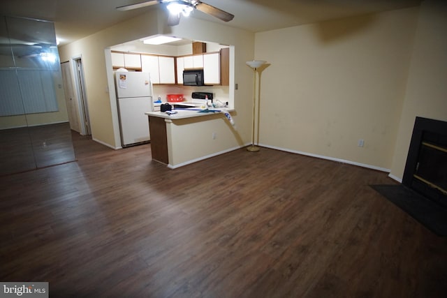 kitchen with stove, a kitchen breakfast bar, white refrigerator, white cabinets, and kitchen peninsula