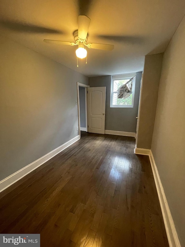 unfurnished room featuring ceiling fan and dark wood-type flooring