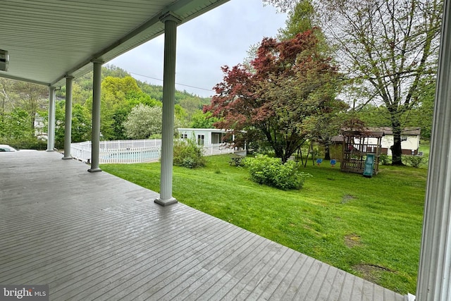 wooden terrace with a swimming pool, a lawn, and a playground