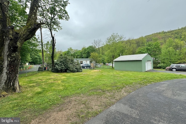 view of yard featuring a garage and an outdoor structure