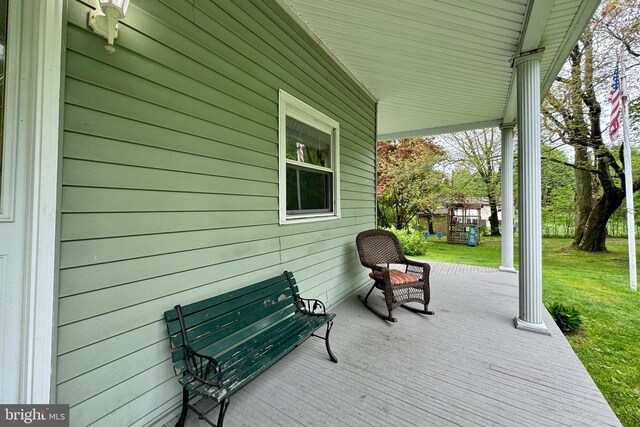 wooden terrace featuring a lawn