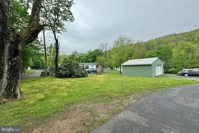 view of yard featuring a garage and an outbuilding