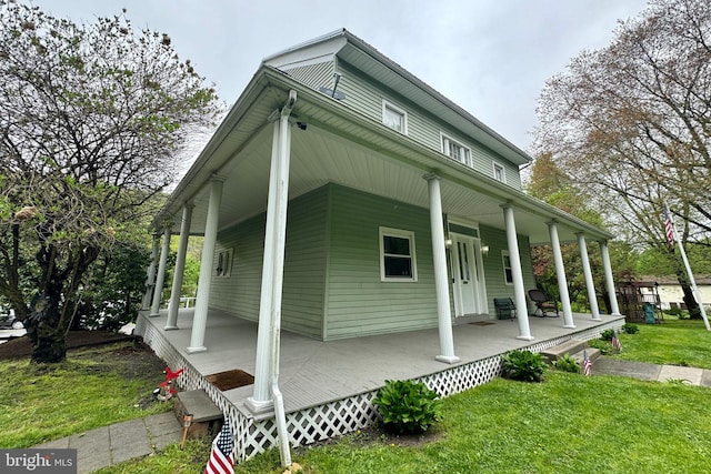 view of property exterior featuring a lawn and covered porch