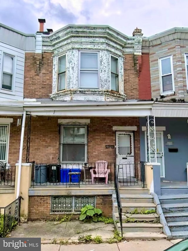 townhome / multi-family property featuring covered porch