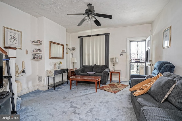 carpeted living room featuring ceiling fan and a textured ceiling