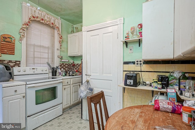 kitchen featuring backsplash, light tile floors, white cabinets, and white electric range