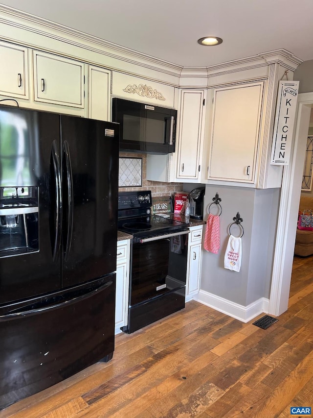 kitchen with backsplash, dark hardwood / wood-style flooring, and black appliances