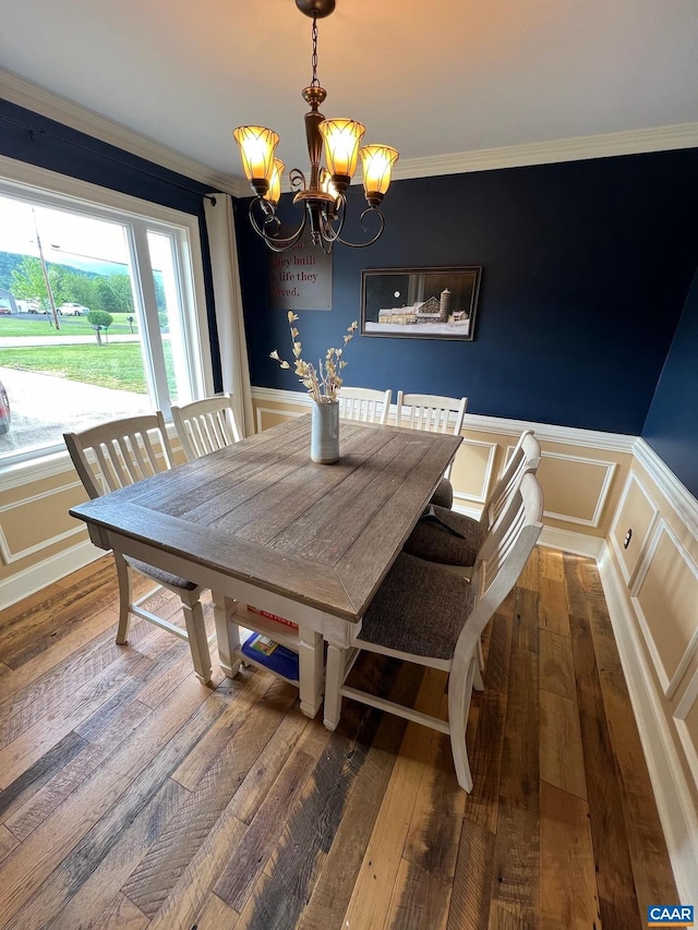 dining room with hardwood / wood-style floors, ornamental molding, and a chandelier