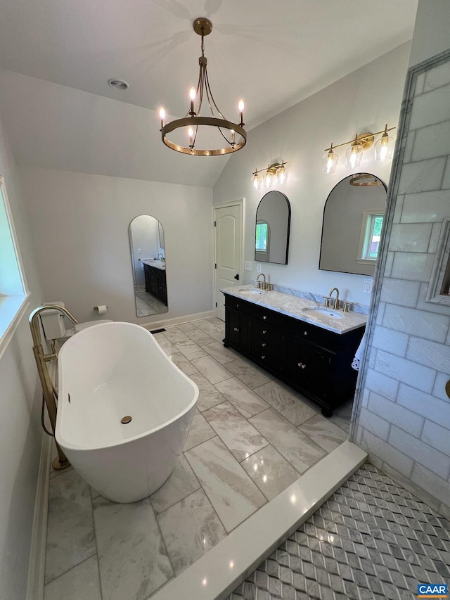 bathroom with tile flooring, large vanity, dual sinks, a notable chandelier, and a bathtub