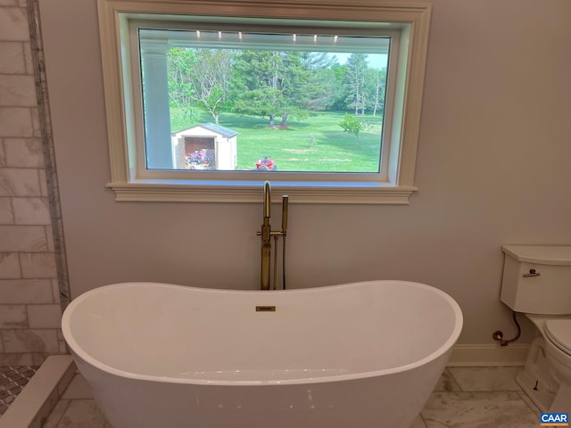 bathroom featuring tile flooring, a shower, toilet, and a wealth of natural light