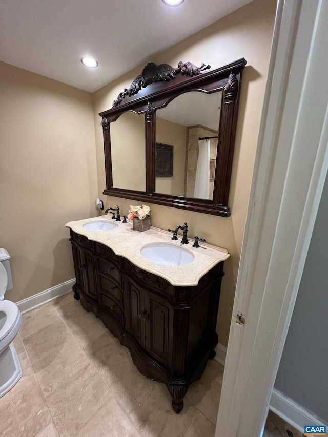 bathroom with dual sinks, toilet, tile flooring, and vanity with extensive cabinet space