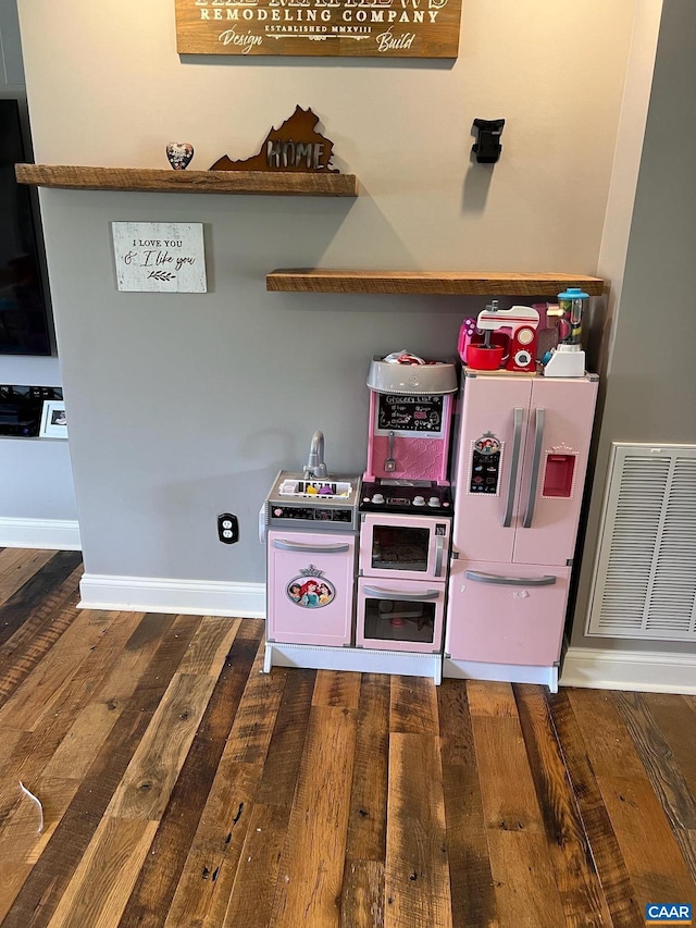 interior space with stainless steel fridge and dark hardwood / wood-style floors