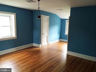 spare room with hardwood / wood-style flooring and lofted ceiling