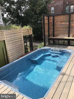 view of pool with a hot tub and a deck