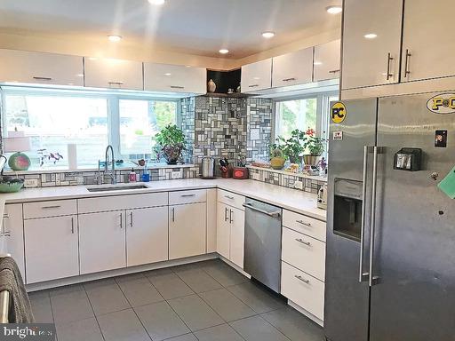 kitchen with stainless steel appliances, a healthy amount of sunlight, tasteful backsplash, and sink