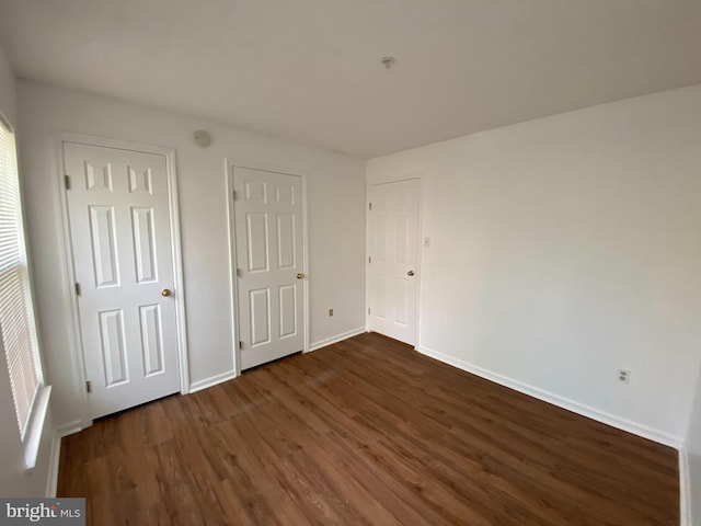 unfurnished bedroom with dark hardwood / wood-style flooring