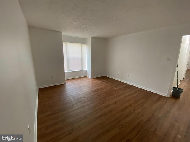 empty room featuring dark hardwood / wood-style floors and a textured ceiling