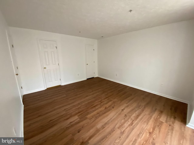 empty room with dark wood-type flooring