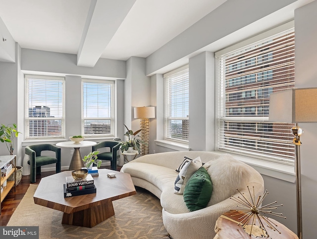 living room with plenty of natural light, dark wood-type flooring, and beamed ceiling