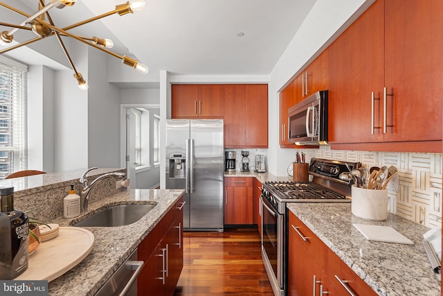 kitchen with light stone countertops, dark wood-type flooring, backsplash, stainless steel appliances, and sink