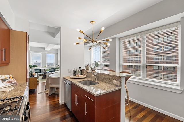 kitchen with sink, light stone countertops, a chandelier, and dark wood-type flooring